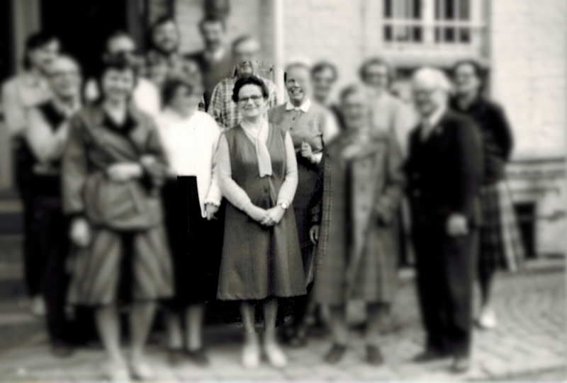 Renate Brauner steht in der Mitte eines Gruppenbildes vor der ehem. Punktschriftdruckerei Wernigerode. Die Teilnehmer des Konventes ders Christlichen Blindendienstes in der DDR, sind unscharf dargestellt.Ca. 1985